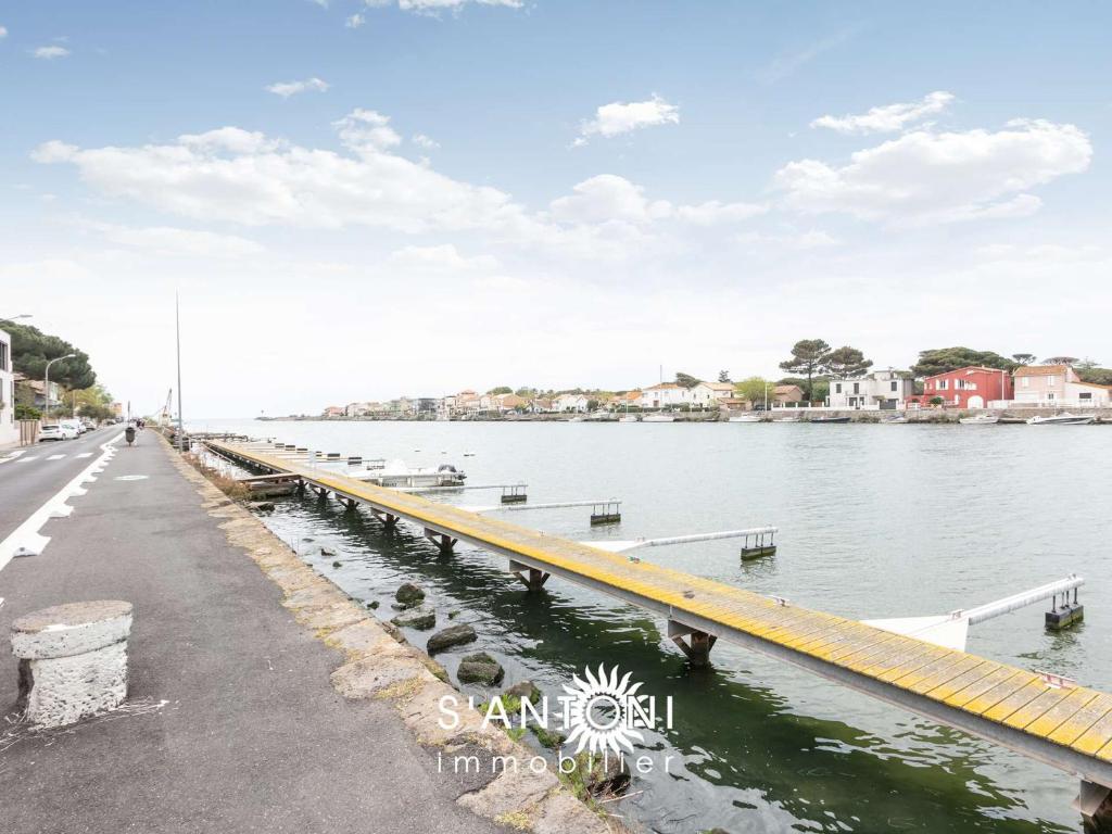 un pont sur l'eau à côté d'une route dans l'établissement Bel appartement 2 pièces climatisé RDC avec terrasse et stationnement, Le Grau d'Agde - FR-1-423-63, au Grau-dʼAgde