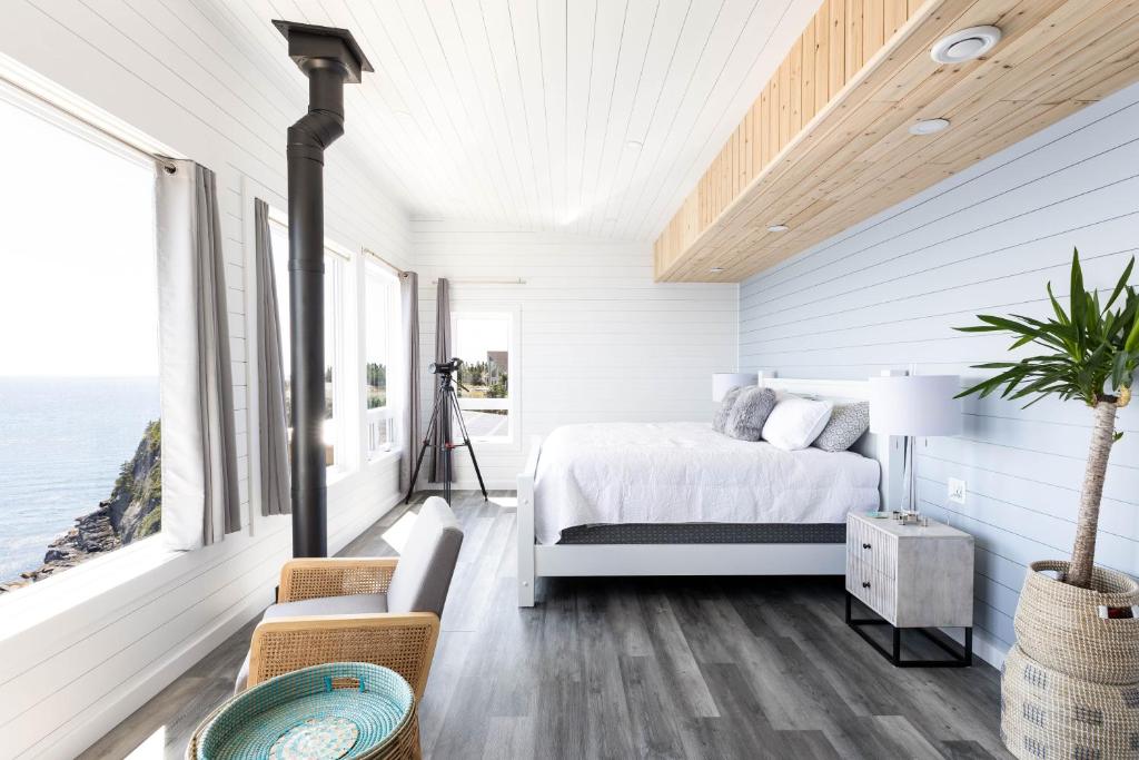 1 dormitorio con cama y vistas al océano en Cliffs Edge Retreat, en Bauline East