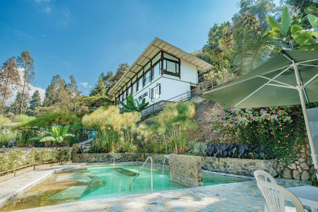 an exterior view of a house with a swimming pool at Hotel Termales Tierra Viva in Manizales