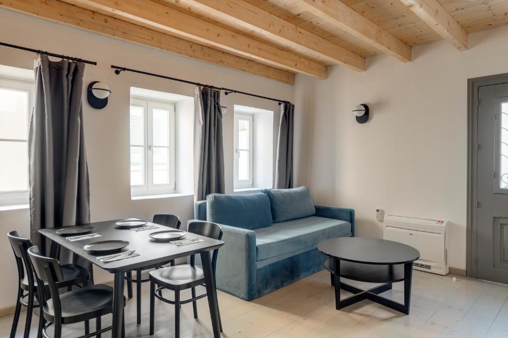 sala de estar con sofá azul y mesa en The Ten Syros, en Ermoupoli