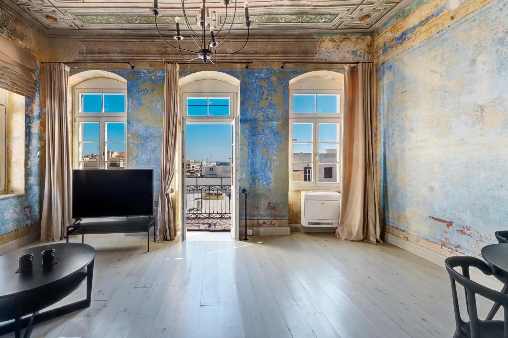 sala de estar con TV y ventana grande en The Ten Syros, en Ermoupoli