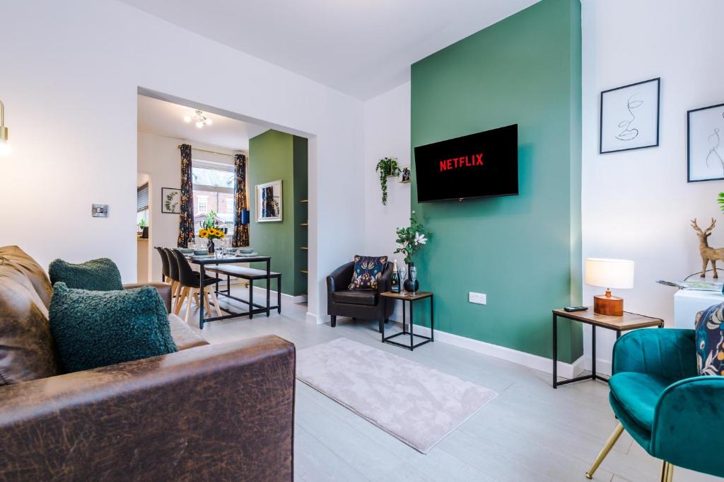 a living room with a couch and a tv on a wall at Stunning 3-bed home in Nantwich by 53 Degrees Property - Amazing location, Ideal for Groups - Sleeps 6 in Nantwich