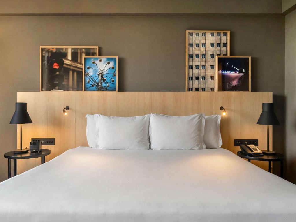 1 dormitorio con 1 cama grande con almohadas blancas en Pullman Sao Paulo Guarulhos Airport en Guarulhos