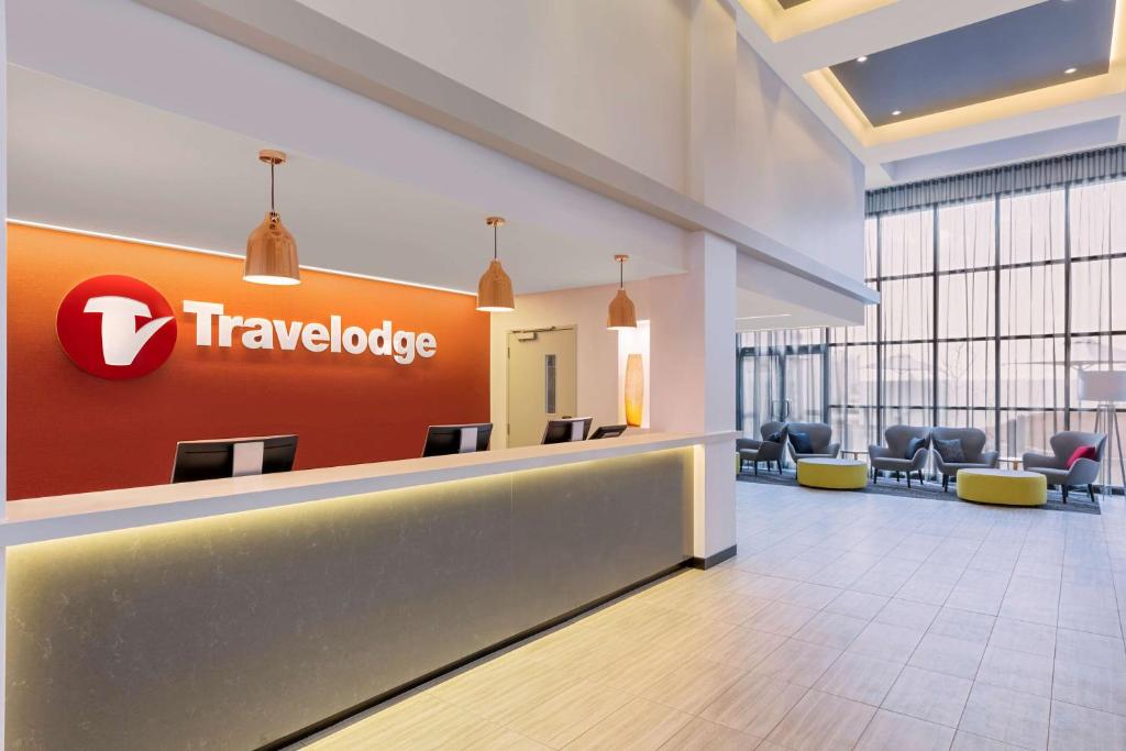 a lobby with a travelodge sign on the wall at Travelodge Hotel Sydney Airport in Sydney