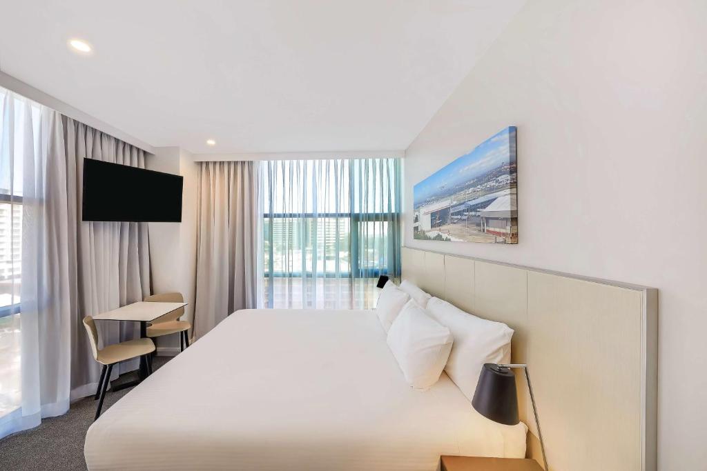 a hotel room with a large bed and a tv at Travelodge Hotel Sydney Airport in Sydney