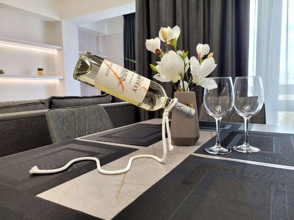 a bottle of wine is being poured onto a table at Dendrarium Park Apartment Deluxe in Chişinău