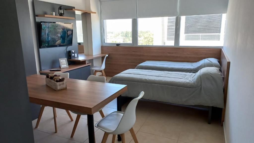 1 dormitorio con cama, escritorio y mesa en Patagonia Home en Cipolletti