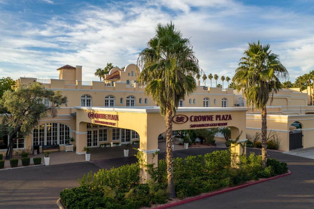 a large building with palm trees in front of it at Crowne Plaza Phoenix - Chandler Golf Resort, an IHG Hotel in Chandler