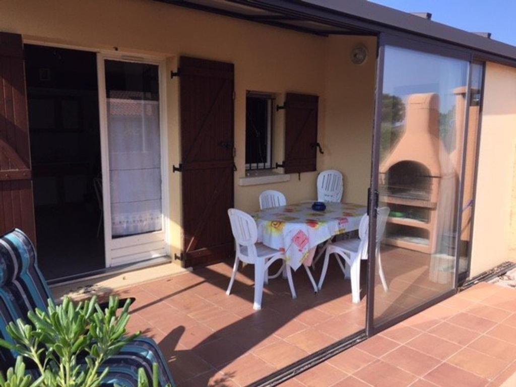 un patio avec une table et des chaises sur un balcon dans l'établissement Villa 3 Pièces, Mezzanine, Clim, 6 Couchages, Près Plage - Le Barcarès - FR-1-81-478, au Barcarès