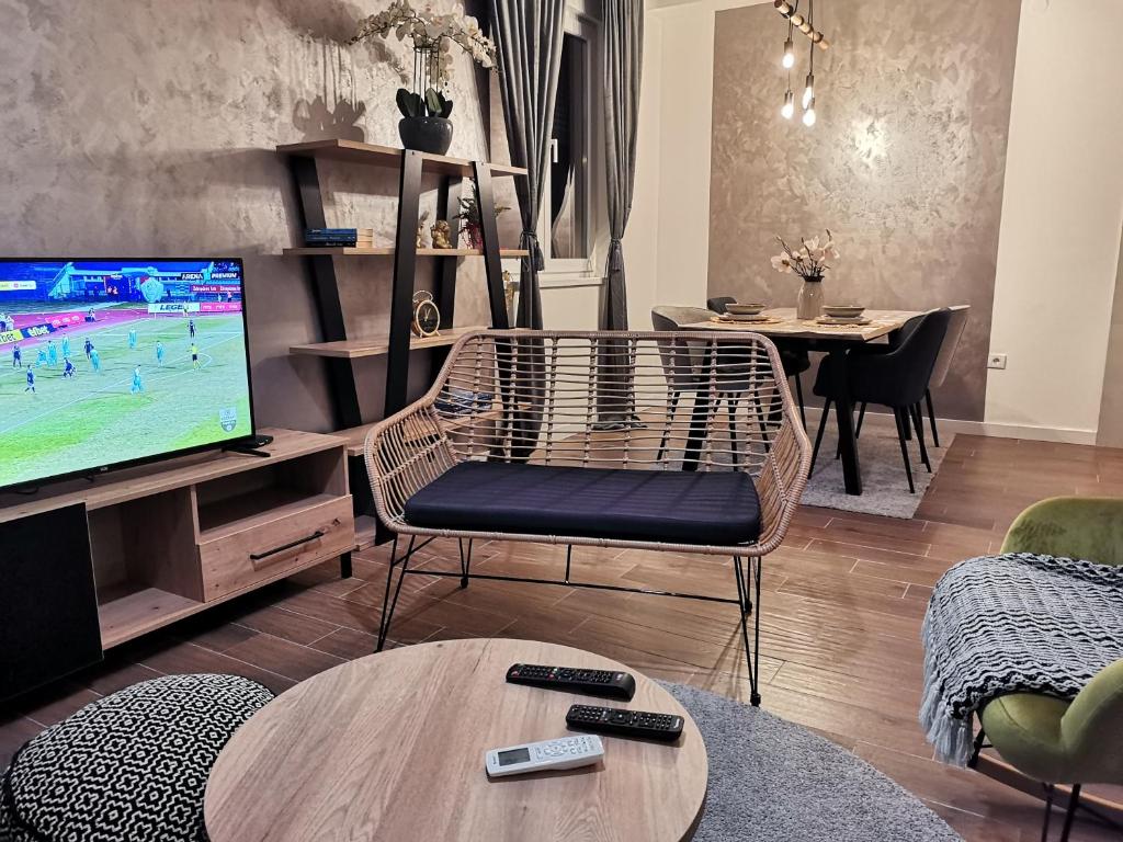 a living room with a tv and a table at Apartment Novi Park Bulatovic in Vrdnik