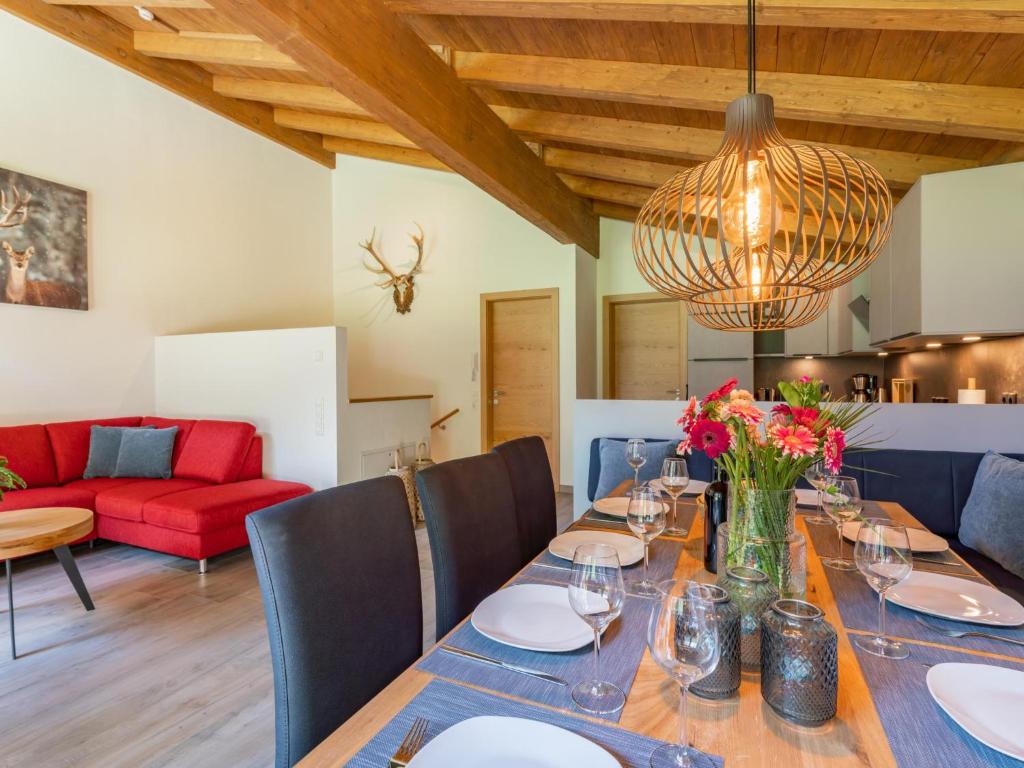 - une salle à manger avec une table et un canapé rouge dans l&#39;établissement Pinzgau Lodge 2D, à Wald im Pinzgau