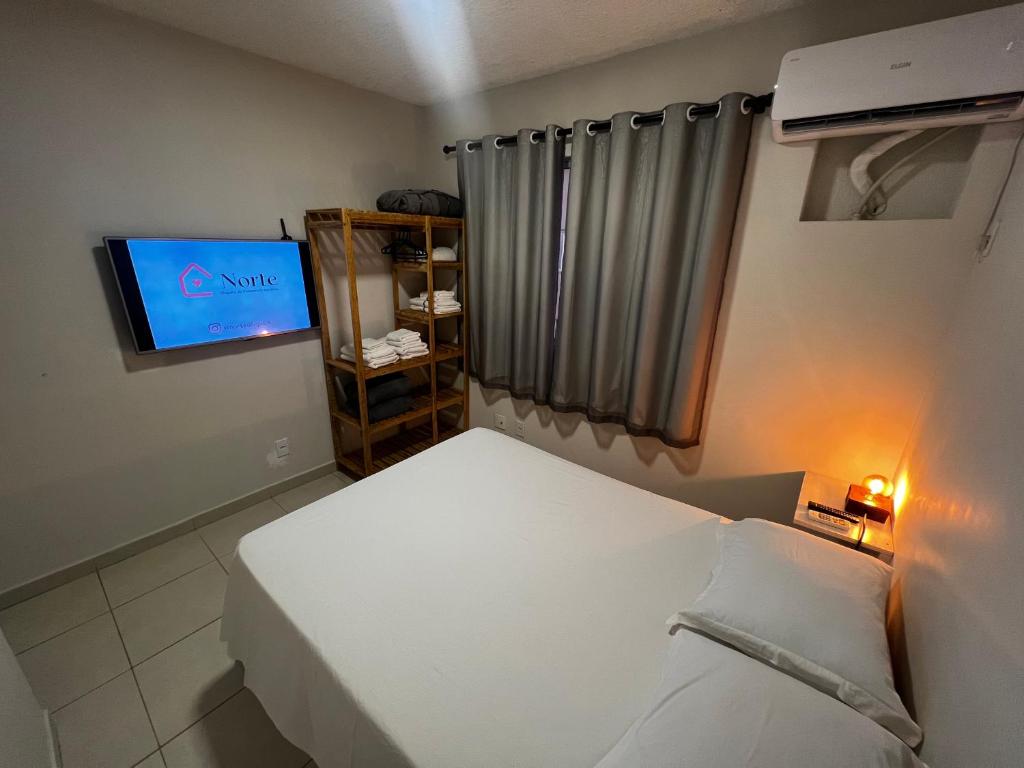 um pequeno quarto com uma cama e uma televisão em Apartamento 4 andar Completo em Condomínio Residencial Familiar em Porto Velho