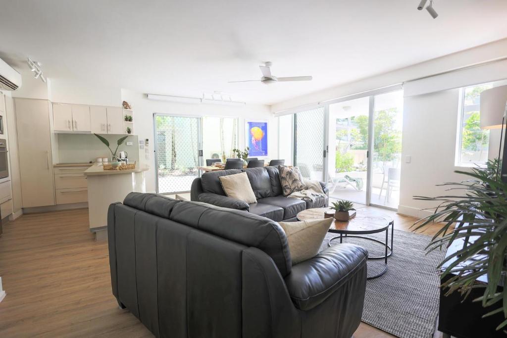 un soggiorno con un divano e un tavolo di The Cove Noosa - Apartment 4 a Noosa Heads