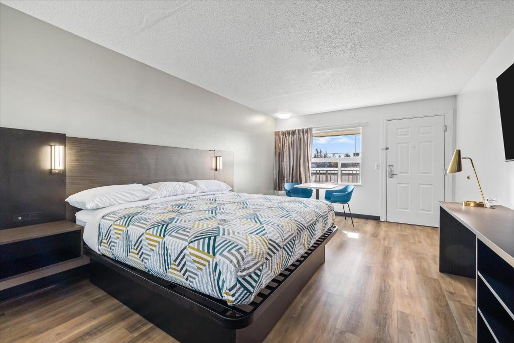 a bedroom with a bed and a table and a window at Motel 6-Bend, OR in Bend