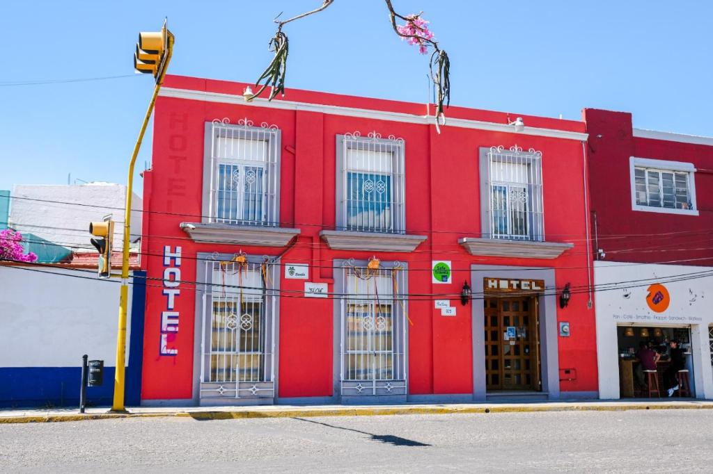 een rood gebouw op de hoek van een straat bij Hotel Posada el Cid in Oaxaca City