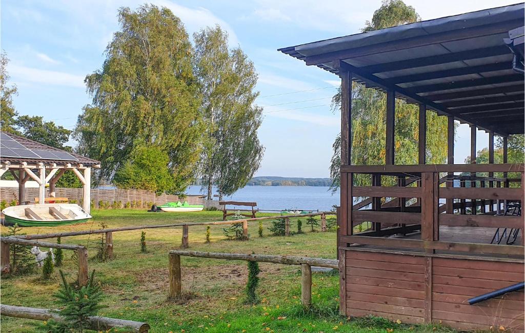 a wooden pavilion with a gazebo and a lake at Nice Home In Biskupiec With House A Panoramic View in Biskupiec