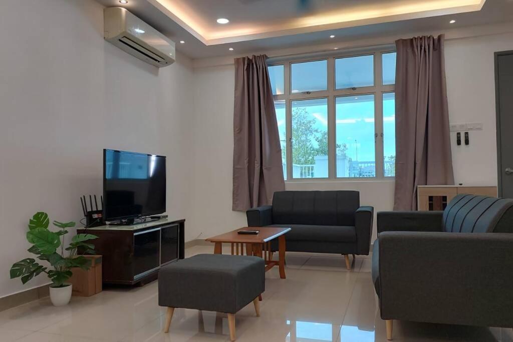 a living room with a couch and a tv at Desaru Nova Guest House with BBQ and Near Tanjung Balau Beach in Bandar Penawar