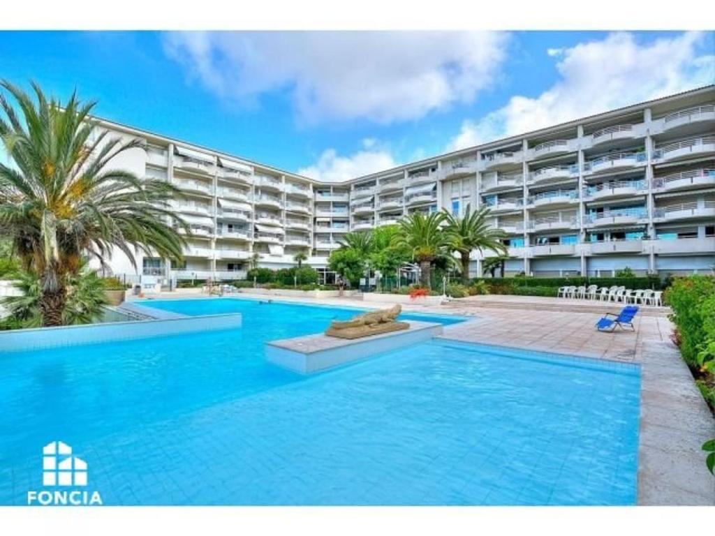 einem Pool vor einem großen Apartmenthaus in der Unterkunft Appartement Juan les Pins, 2 pièces, 4 personnes - FR-1-252-169 in Antibes