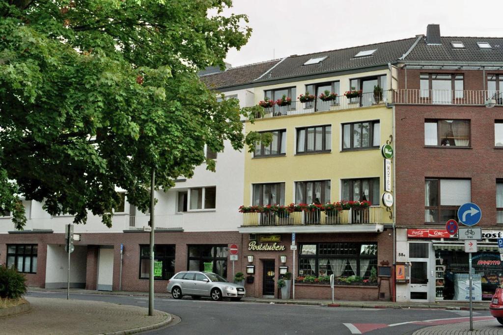 un edificio en una calle con un coche aparcado delante en Zentral Hotel Poststuben, en Krefeld