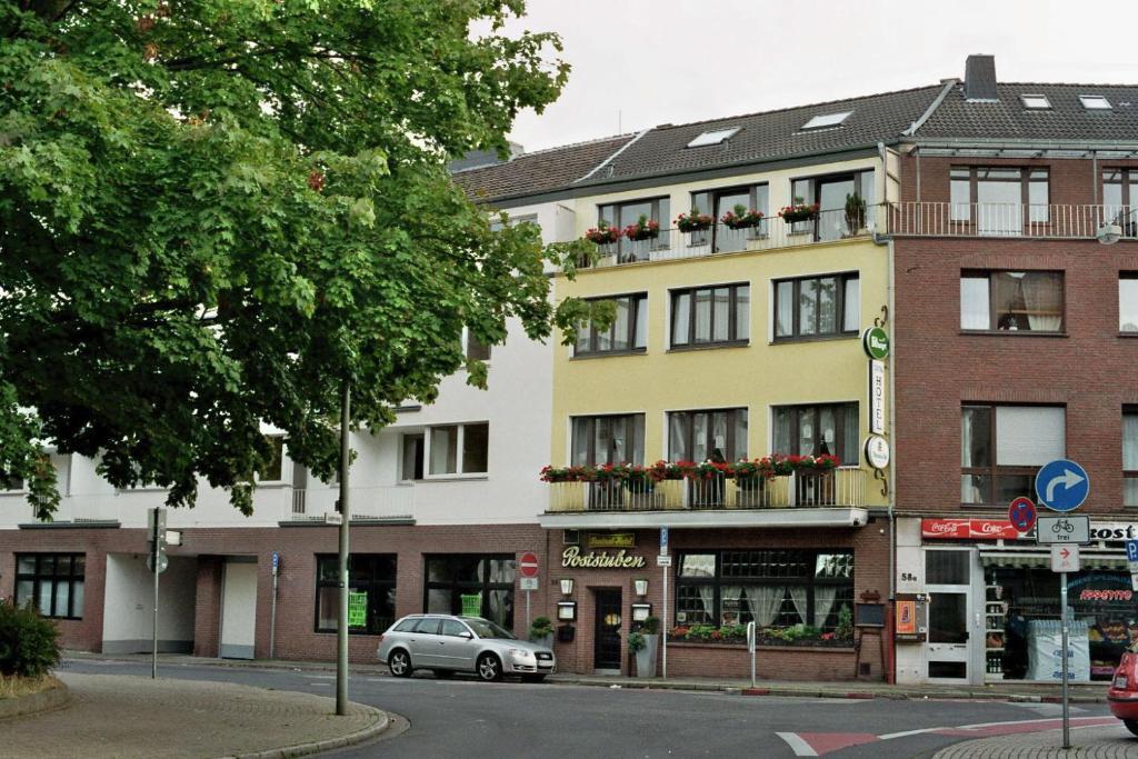 a building on a street with a car parked in front at Zentral Hotel Poststuben in Krefeld