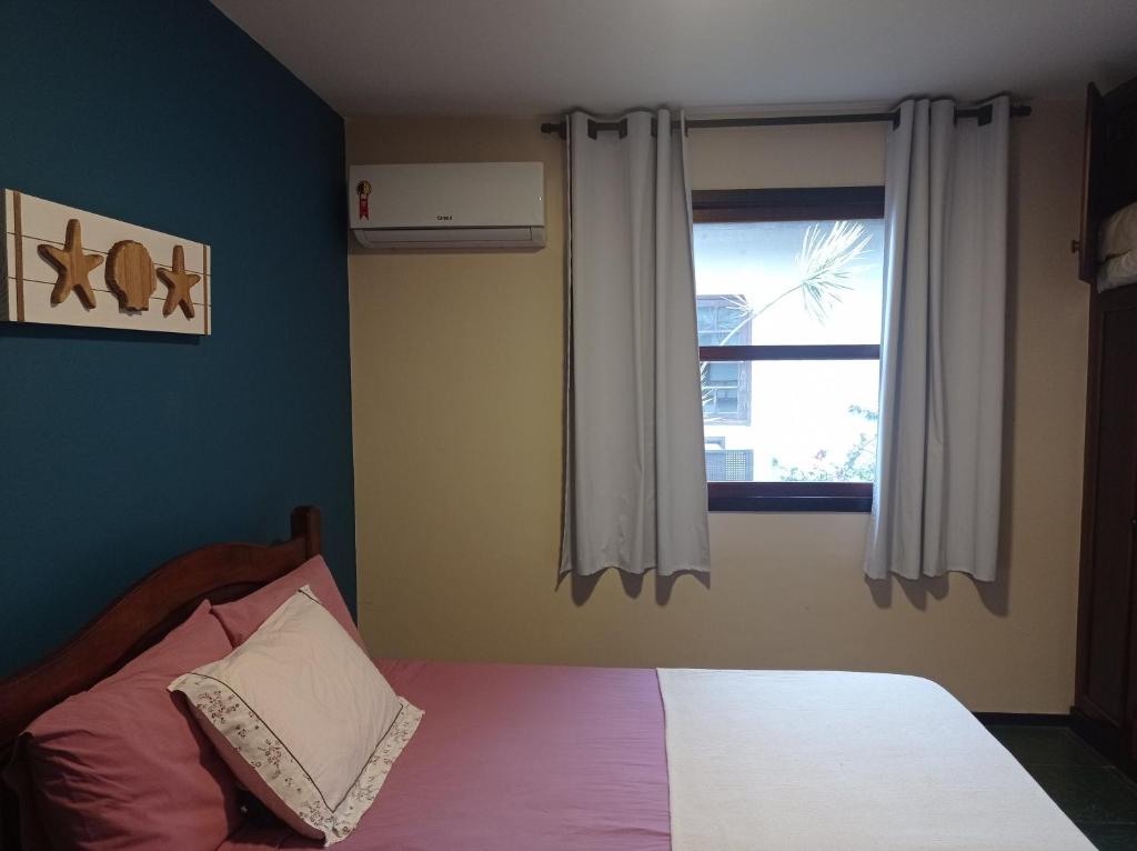 a bedroom with a bed and a window at Le Corsaire in Búzios