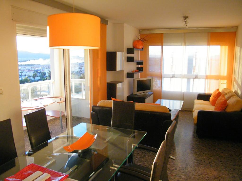 sala de estar con sofá y mesa de cristal en Apartamentos Milenio, en Cullera