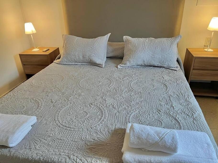 1 cama grande con sábanas y almohadas blancas en Departamento en macro centro en Salta