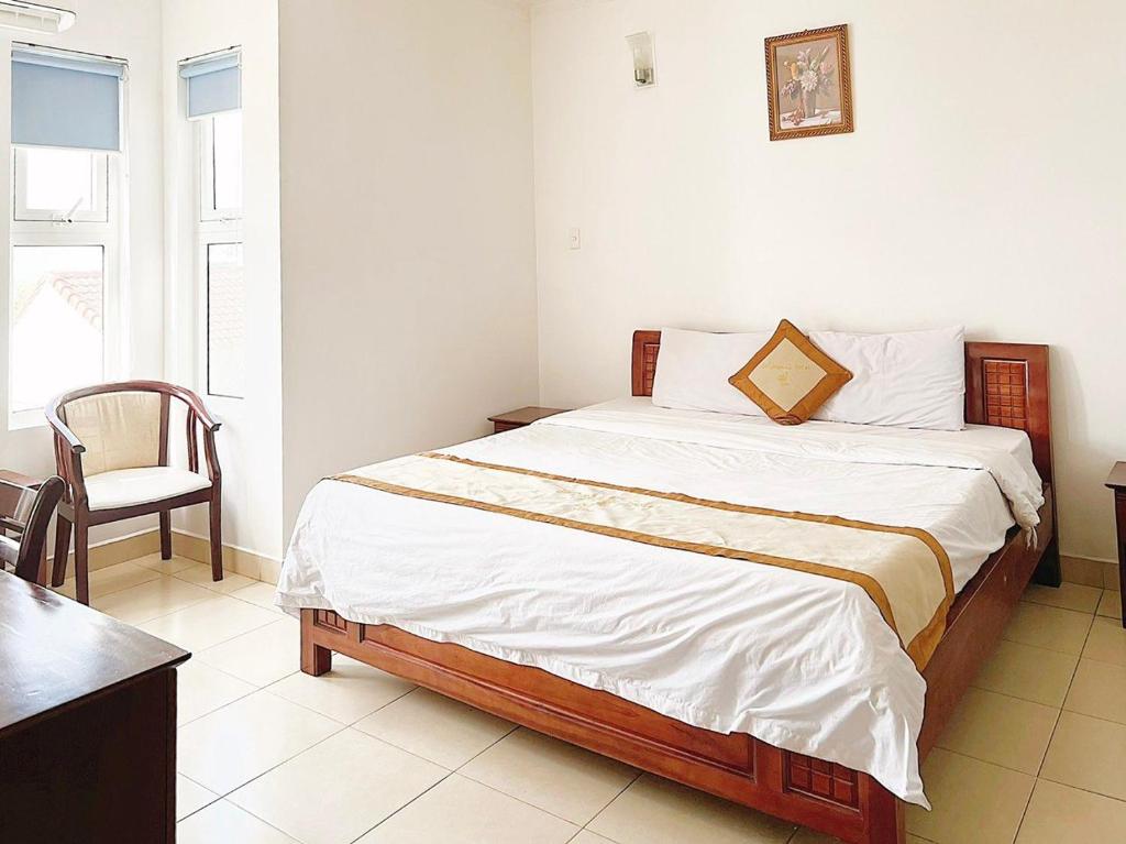 1 dormitorio con 1 cama con silla en AMANDA HOTEL ĐÀ NẴNG en Da Nang