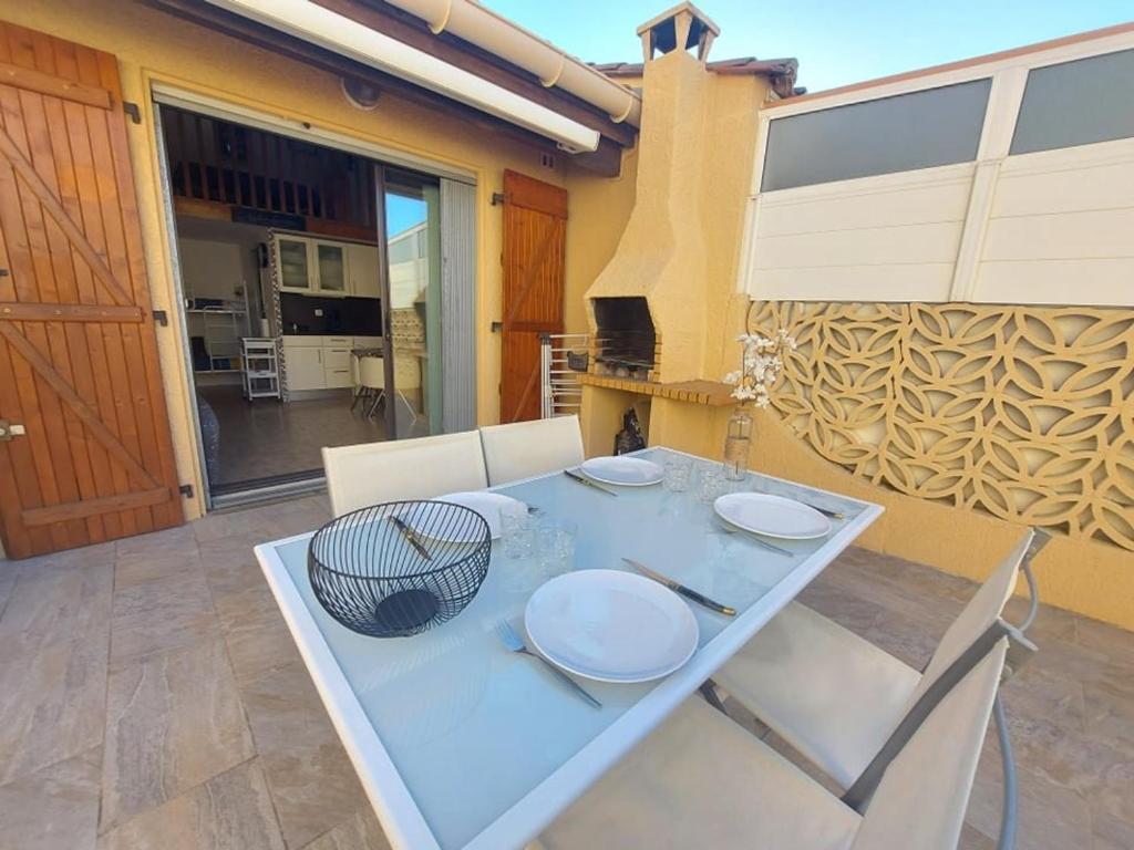 une table bleue avec des plaques blanches au-dessus dans l'établissement Maison Climatisee 4 Couchages avec Terrasse et Parking à 300m de la Plage - FR-1-326-744, à Marseillan