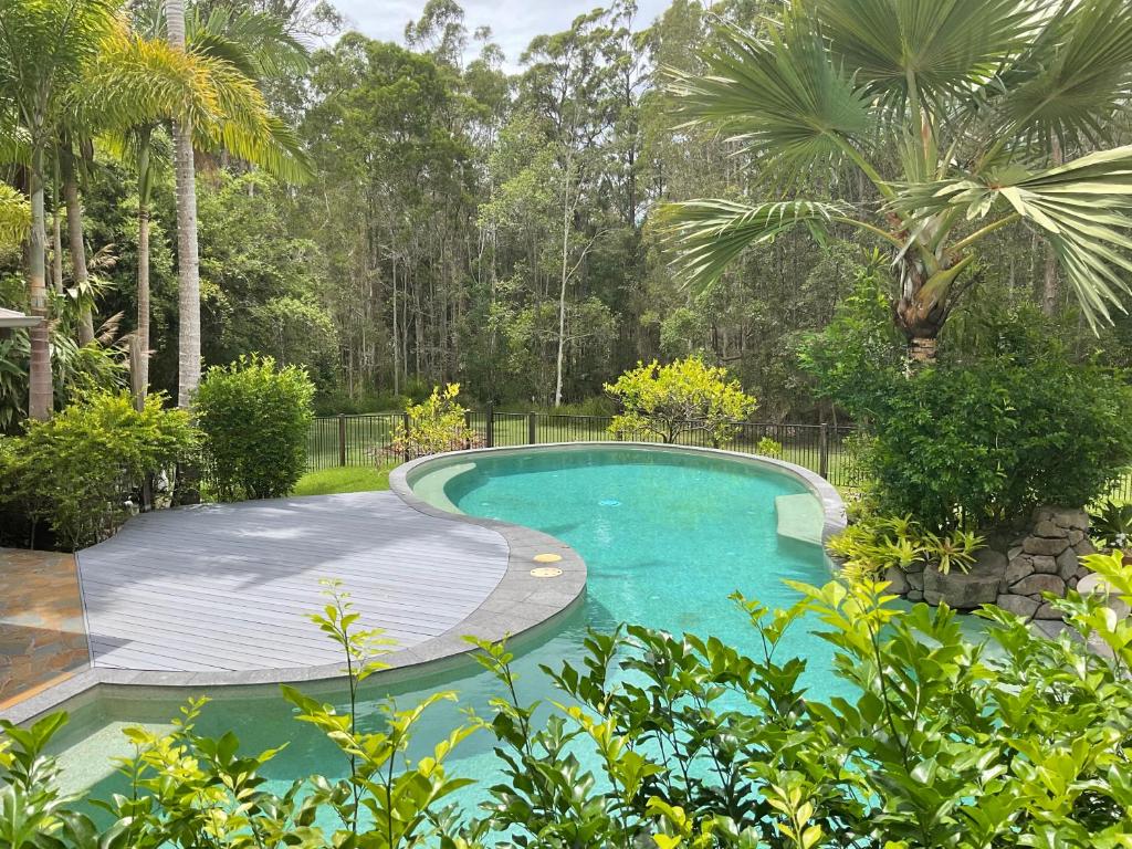 a swimming pool in a garden with a wooden deck at Clearwater estate in Doonan