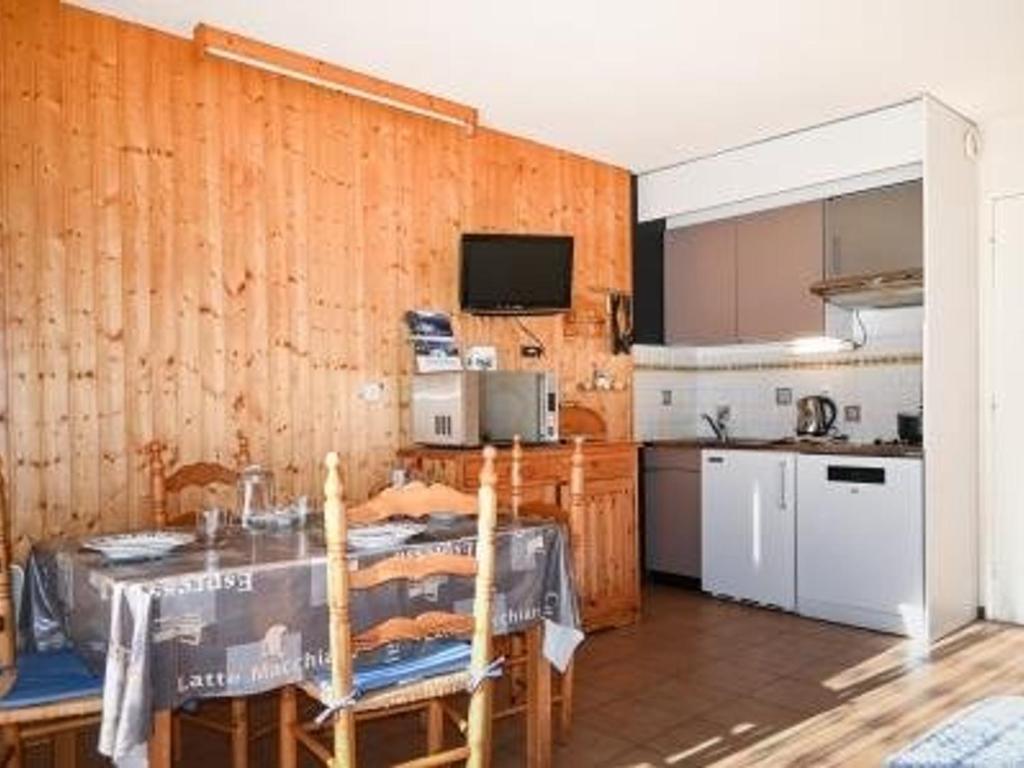 une cuisine avec une table et des chaises et une cuisine avec une table dans l'établissement Studio confortable pour 4 pers. avec kitchenette et parking à Montgenèvre - FR-1-266-189, à Montgenèvre