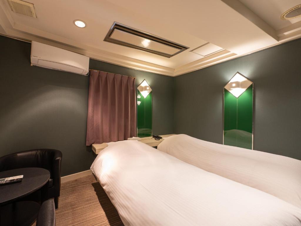 Postel nebo postele na pokoji v ubytování Tabist Hotel Rakuserina
