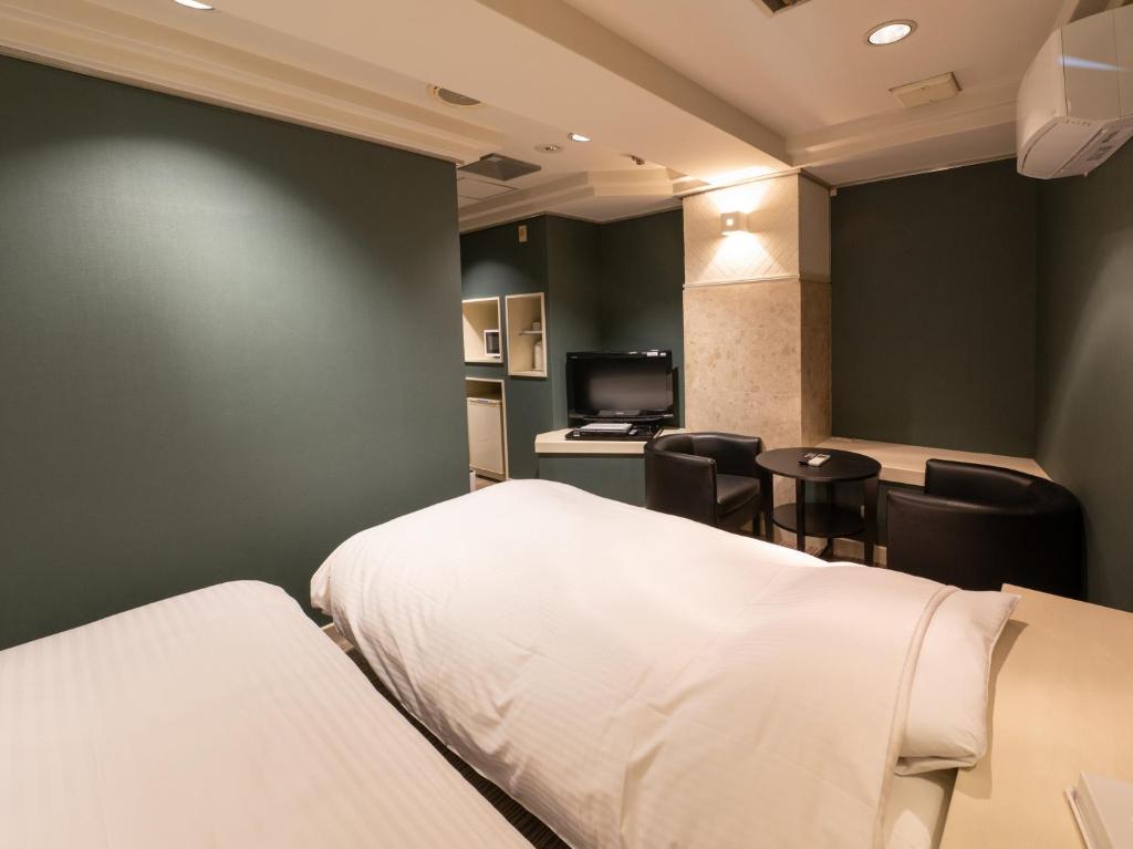 Postel nebo postele na pokoji v ubytování Tabist Hotel Rakuserina