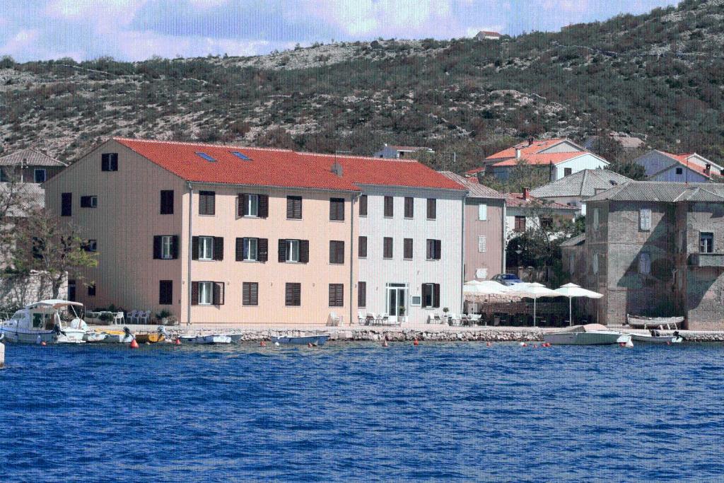 un gran edificio en el agua junto a un muelle en Apartments Tamarix, en Vinjerac