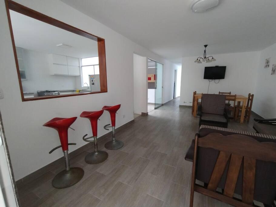 a living room with red chairs and a mirror at J&B Aparment 1 Punta Hermosa in Punta Hermosa