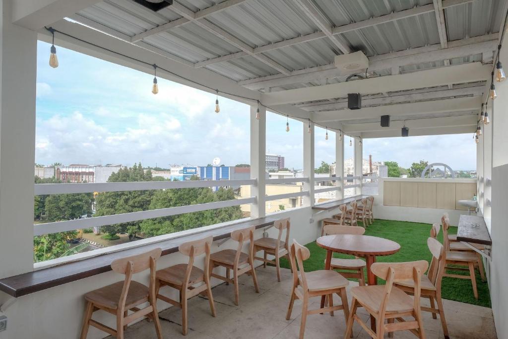 a balcony with tables and chairs and a view of the city at KoolKost Syariah at Ir Soekarno Solo Baru in Solo