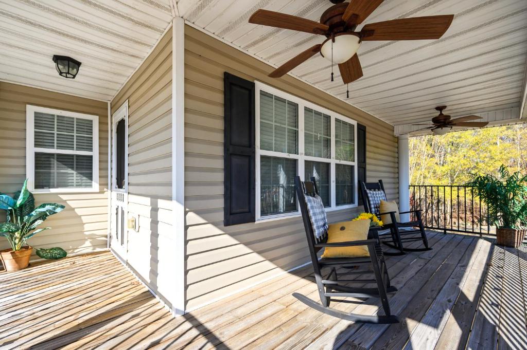a porch with two rocking chairs and a ceiling fan at Spacious Serene 3BR Near LakePoint & DT Acworth in Acworth