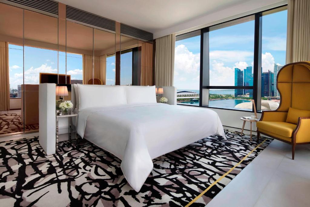 シンガポールにあるJW Marriott Hotel Singapore South Beachのベッドルーム(大きな白いベッド1台、椅子付)