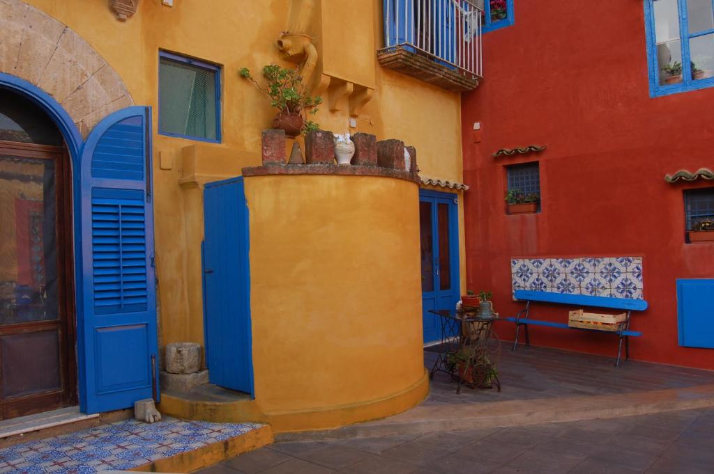 a yellow and blue building with blue doors at Duca di Castelmonte in Trapani