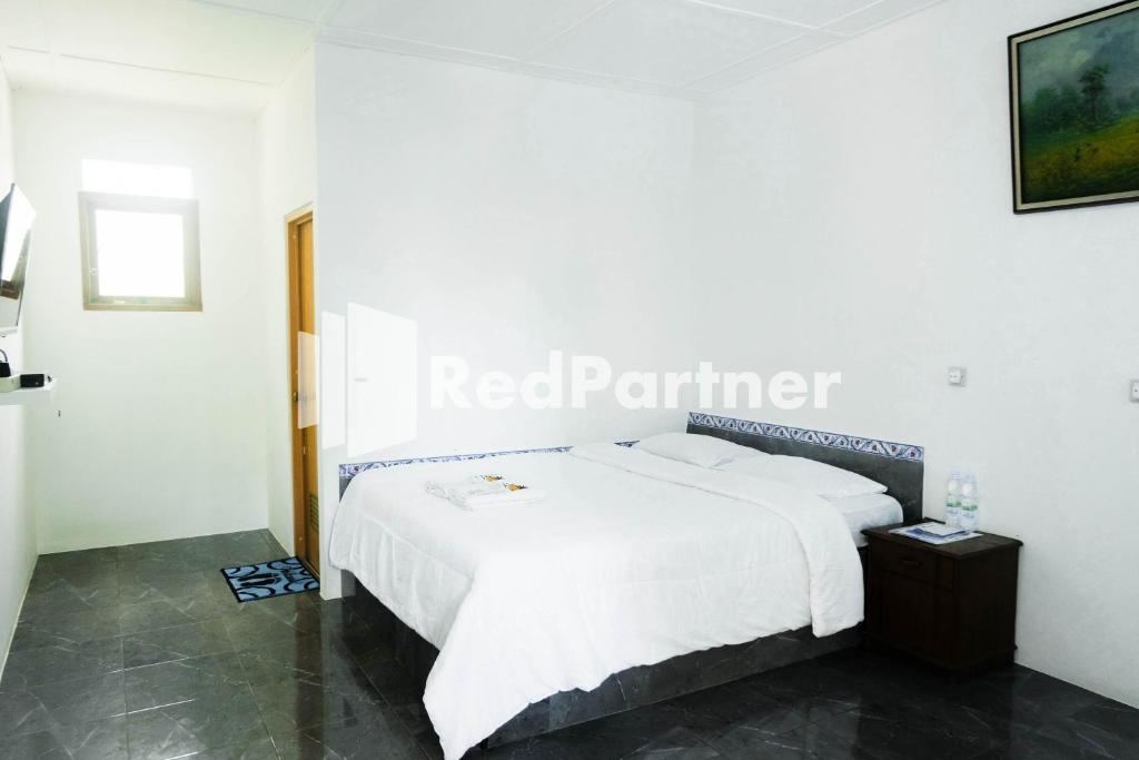 una cama blanca en una habitación con una señal de perímetro rojo en Ken Zong Inn Hotel, en Cijaringao