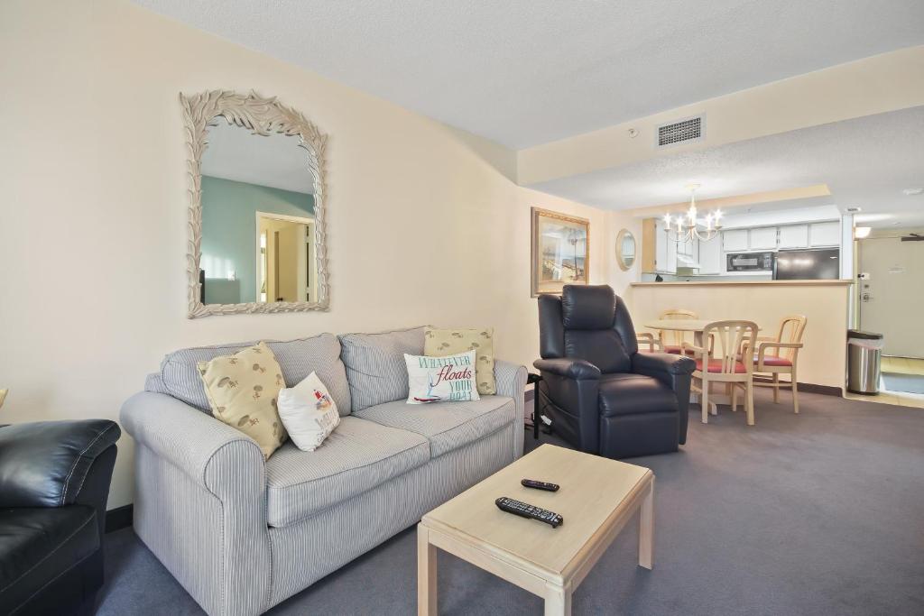 uma sala de estar com um sofá e uma mesa em Beach Colony 415 em Myrtle Beach