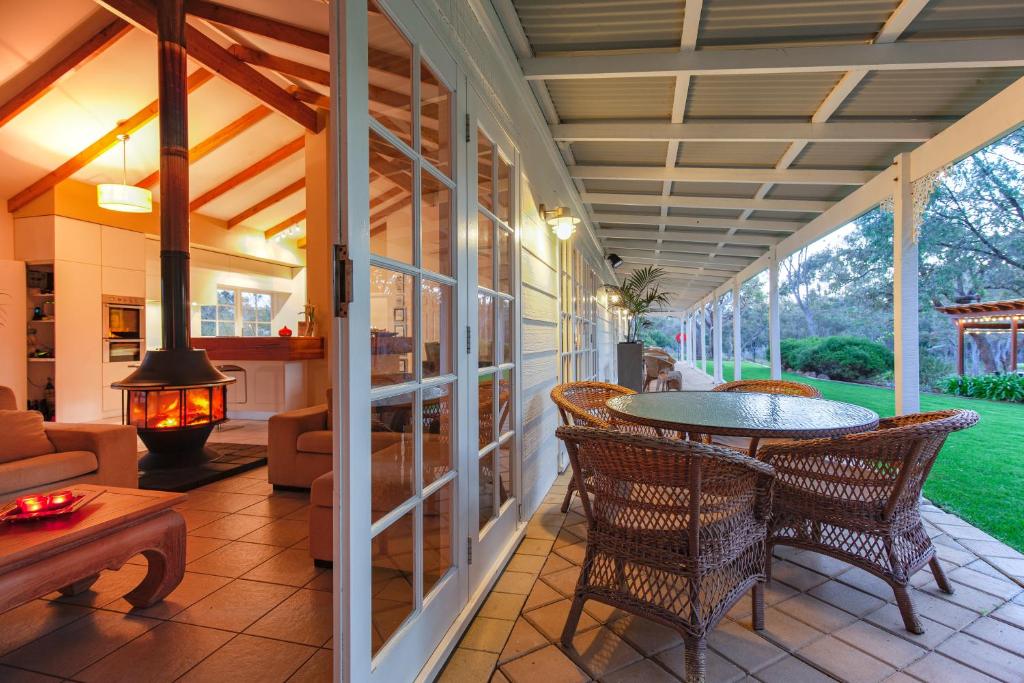 a screened in porch with a table and chairs at Llewellin's Guest House in Margaret River Town