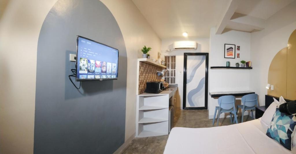 um quarto com uma televisão numa parede com um quarto em Hive Manila Guesthouse and Apartments 400 Mbps - Gallery Studio em Bacoor