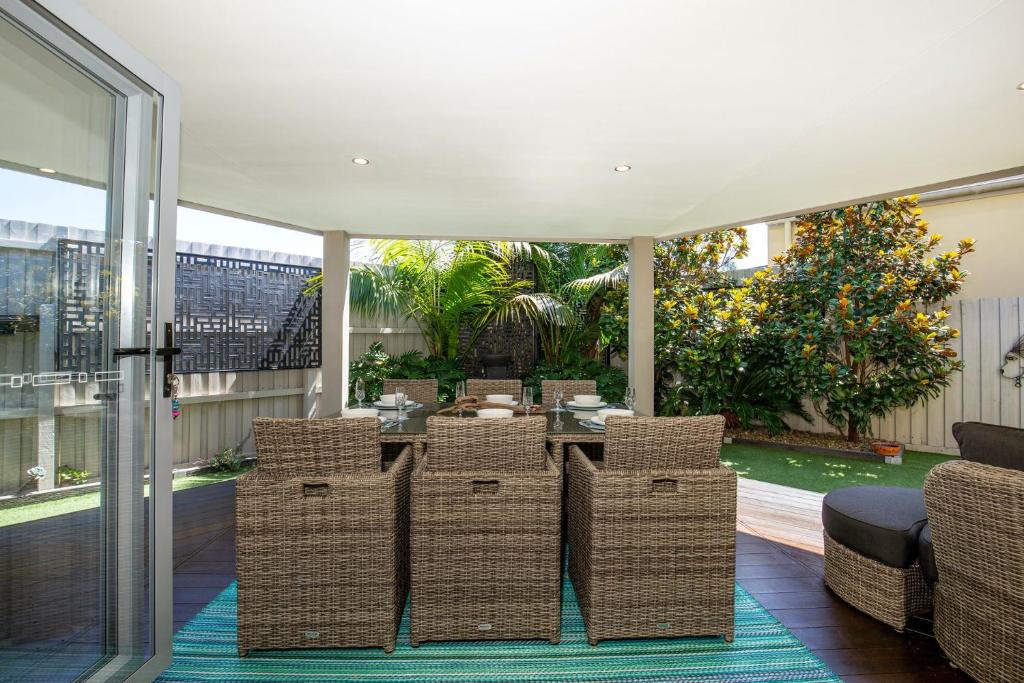 a dining room with wicker chairs and a table at Bowers Nest Pet Friendly 2 Mins Walk to Beach in Culburra Beach