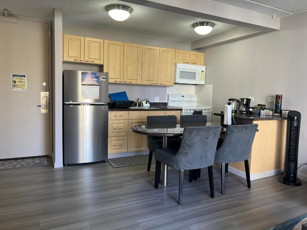 a kitchen with a table and chairs and a refrigerator at Waikiki Sunset in Honolulu