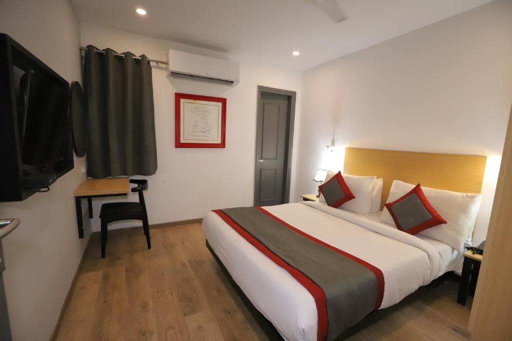 a hotel room with a large bed and a television at Hotel IP Residency Anand Vihar in New Delhi