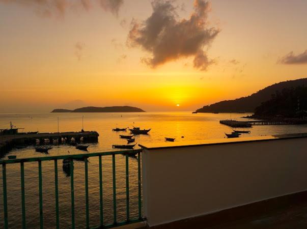 un coucher de soleil sur un port avec des bateaux dans l'eau dans l'établissement Chàm’s Corner Lookout Homestay & Restaurant, à Tân Hiệp