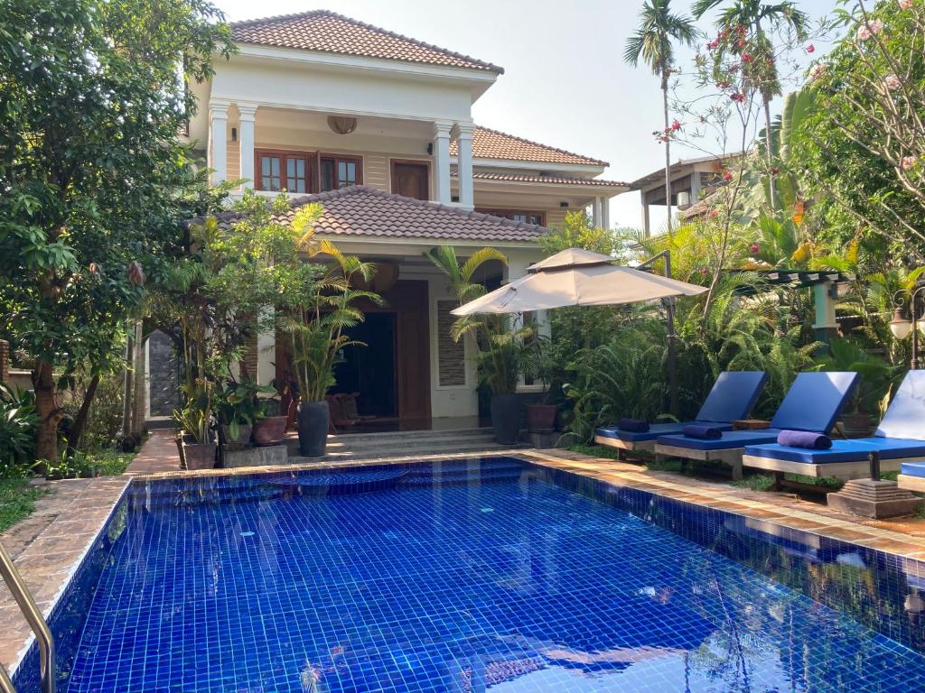 a villa with a swimming pool in front of a house at Lily Pad Boutique Hotel in Siem Reap