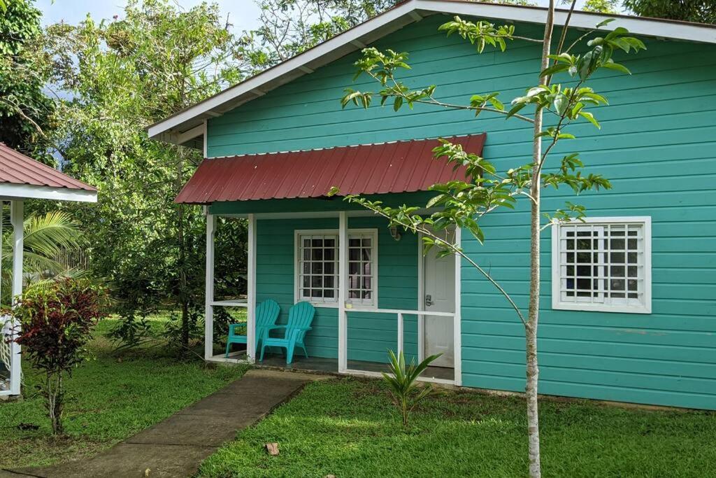 a blue house with a red roof at Big Creek Casita in Bocas del Toro