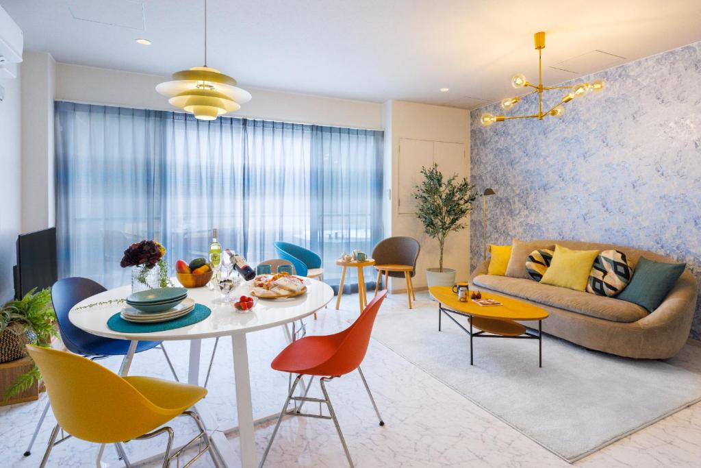 sala de estar con mesa, sillas y sofá en Southerlies Condominium Onna en Onna